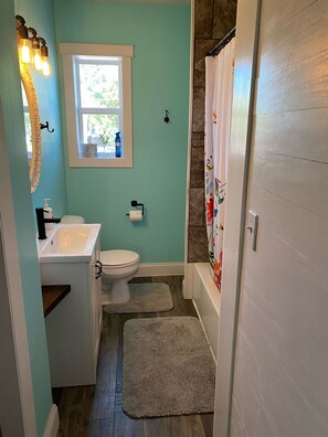 Tina con regadera, secadora de cabello, toallas 