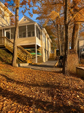 Un bâtiment à deux étages doté d’un espace extérieur couvert, d’un escalier et d’arbres aux feuilles d’automne.