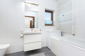 Bathtub, hair dryer, towels, shampoo