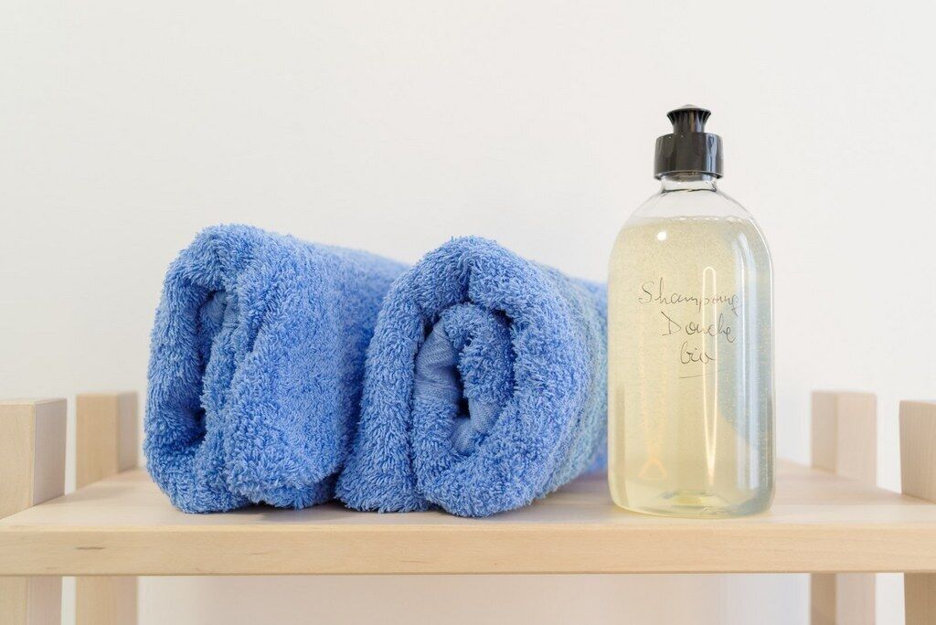 Een bad/douchecombinatie, een haardroger, handdoeken, zeep