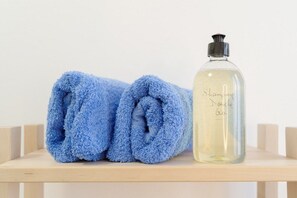 Een bad/douchecombinatie, een haardroger, handdoeken, zeep