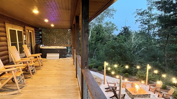 A wooden deck with outdoor seating and a fire pit area.