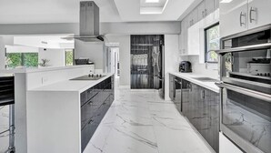 A modern kitchen with a central island, built-in appliances, and a skylight. - Welcome to Paradise! 1 mile to beach heated pool! (Hollywood)