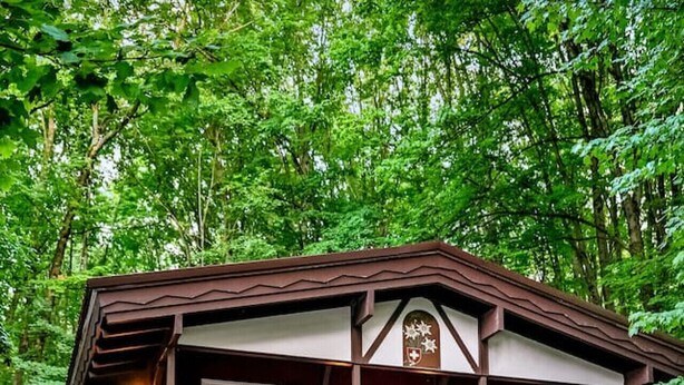 A two-story lodge with a balcony, outdoor seating, and a staircase leading to the upper level. - Chalet Getaway | Hot tub | Sauna | Firepit | Pool (Bellaire)