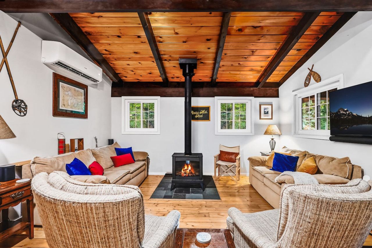 A cozy living room with a fireplace, two sofas, and wicker chairs.