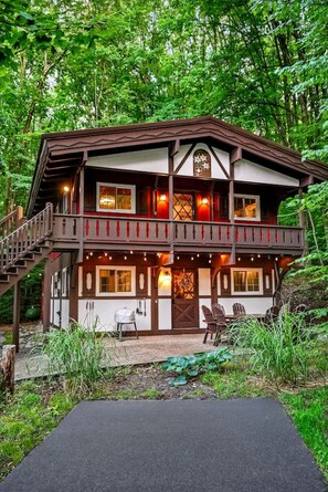 A two-story lodge with a balcony, outdoor seating, and a staircase leading to the upper level. - Chalet Getaway | Hot tub | Sauna | Firepit (Bellaire)