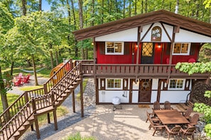 A two-story chalet with a wooden staircase, a deck, and outdoor seating. - Chalet Getaway: Hot Tub, Sauna & Fire Pit (Bellaire)