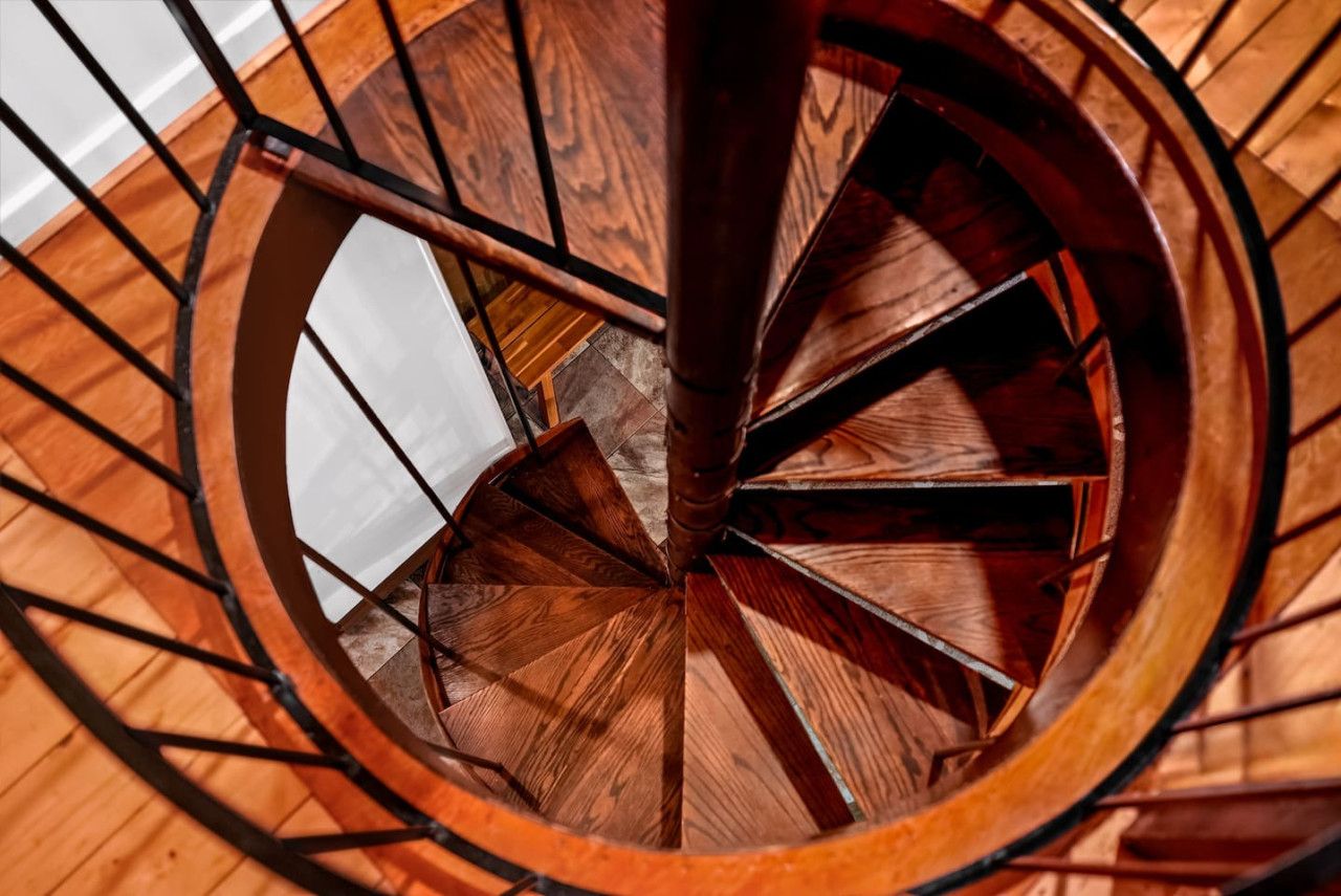 A spiral staircase with wooden steps and metal railings.