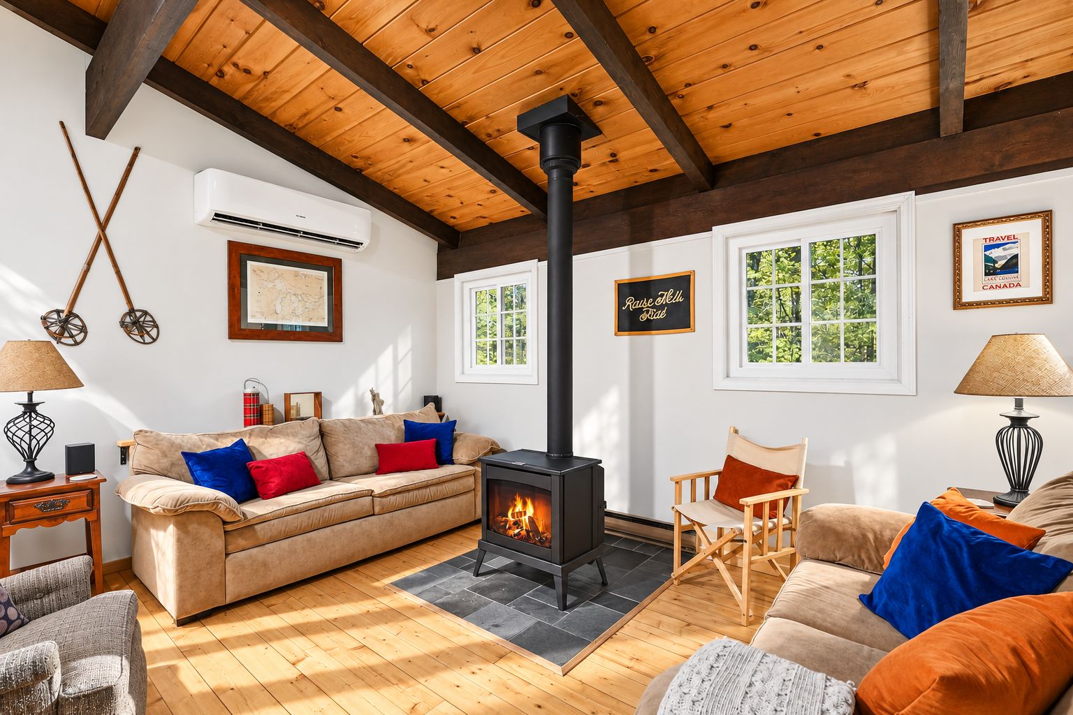 A cozy living room with a fireplace, wooden beams, a sofa, and a chair.