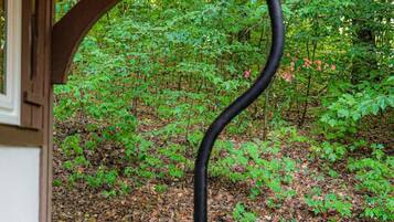 Un banco de madera con estructura de soporte metálica negra en un jardín.