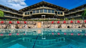 A hotel with a large pool, multiple balconies, and outdoor seating areas. - Chalet Getaway | Hot tub | Sauna | Firepit | Pool (Bellaire)