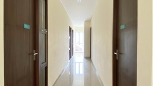 A hallway with doors numbered 207 and 212, leading to rooms. - Reddoorz @ Arkana Seturan (Depok)