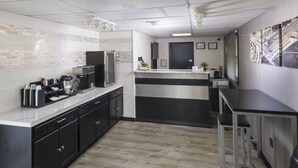 A modern kitchen with black cabinets, a marble countertop, and stainless steel appliances. - Sunrise Inn Hershey (Hershey)