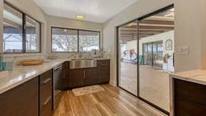 A modern kitchen with a large window, a built-in sink, and a wooden floor. - NOW ACCEPTING ONE YEAR LEASES ON OUR WATERFRONT HOME! (Merritt Island)