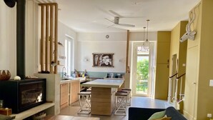 Una cocina moderna con una isla central, una zona de comedor con sofá y una chimenea.
