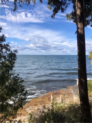 A view of a beach with calm water and a clear sky. - Waterfront Log Home, WiFi, 3 bedrooms, Direct TV, Fire Pit (Egg Harbor)