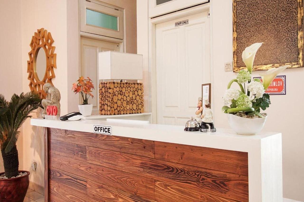 A reception desk with a wooden front panel, a sign indicating 'OFFICE', and a 'STAFF ONLY' door in the background.