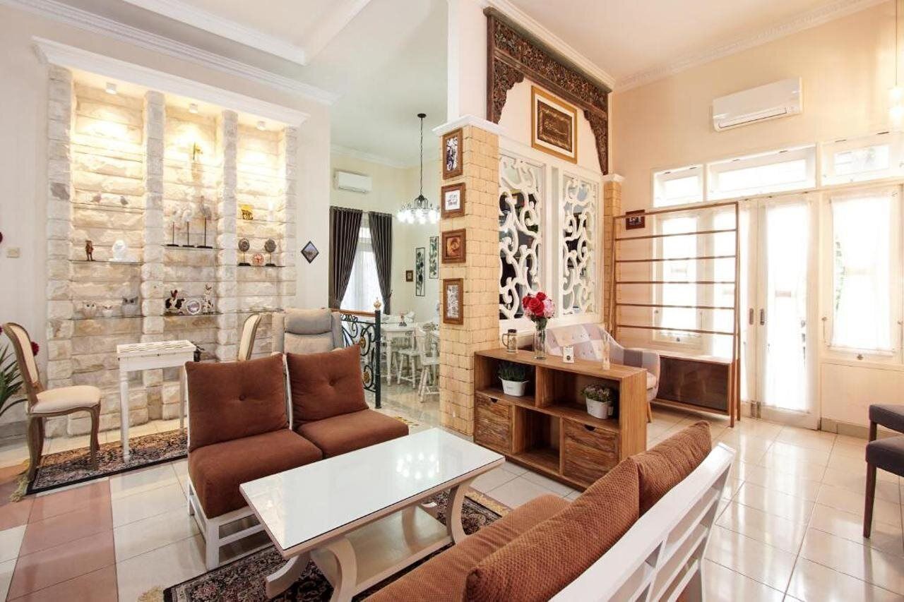 A spacious living room with a stone fireplace, a white coffee table, and brown sofas.