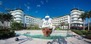 A large, modern hotel with a central courtyard featuring a decorative fountain and a ship model. - Hilton Garden Inn Shenzhen Dameisha (Shenzhen)