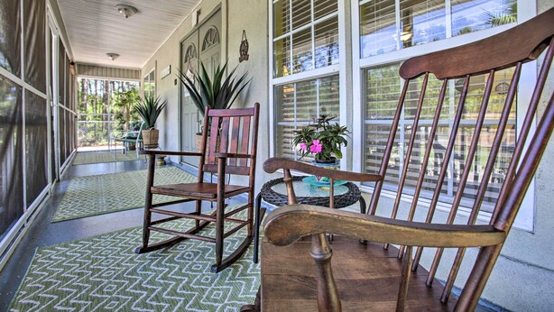 A covered porch with rocking chairs, a small table, and potted plants. - 'Cloud 9 On The Coast' < 1 Mi to Beach! (Waveland)