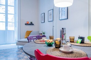 Un comedor moderno con una mesa redonda, sillas y una cafetera.