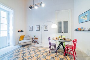 Un comedor con una mesa redonda, sillas, una lámpara de pie y un sofá.