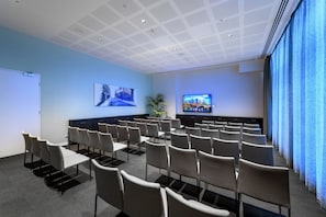 A conference room with rows of chairs, a whiteboard, a television, and a plant. - Ibis Melbourne Central (Melbourne)