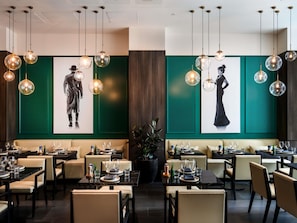 A restaurant with round table settings, hanging spherical light fixtures, and green accent walls. - Ibis Melbourne Central (Melbourne)