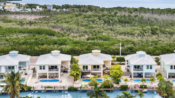 Ett semesterhotell med flera byggnader, en swimmingpool och utsikt över havet.