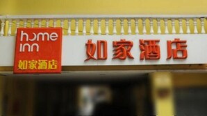 Ein Hotelschild mit der Aufschrift "home inn" und "如家酒店", das eine wohnliche Unterkunft anzeigt.