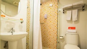 Ein Badezimmer mit Waschbecken, Toilette, Duschvorhang und gefliesten Wänden.
