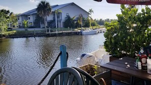 Une vue sur le bord de l’eau, avec une maison, un quai et un bateau.