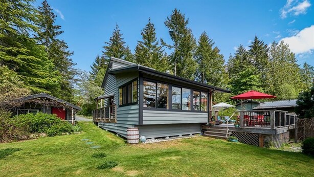 Una casa moderna con una terraza amplia y un patio cubierto.