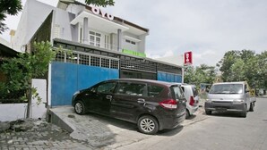 A building with a blue gate and a car parked in front. - OYO 3170 Songo Residence (Semarang)