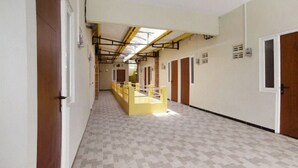 A corridor with lockers, a yellow barrier, and doors leading to rooms. - OYO 3170 Songo Residence (Semarang)