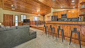 A spacious living room with a grey sofa and a wooden ceiling. - 2 Decks & Game Room: Expansive Family Cabin (Pinetop-Lakeside)