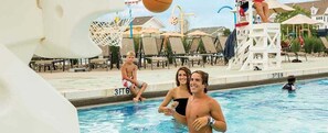Une piscine avec des chaises longues et un poste de surveillance pour les sauveteurs.