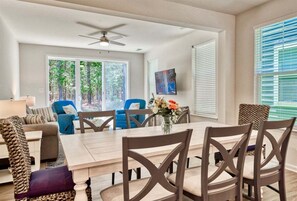 A dining area with a table, chairs, and a ceiling fan.