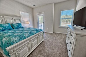 Une chambre à coucher avec un lit, une commode et un téléviseur.