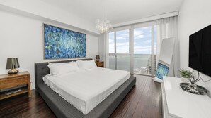 A modern bedroom with a large bed, a city view, and a flat-screen TV. - ICON W BRICKELL MARVELOUS OCEAN VIEW 2BR/2BA #4508 (Miami)