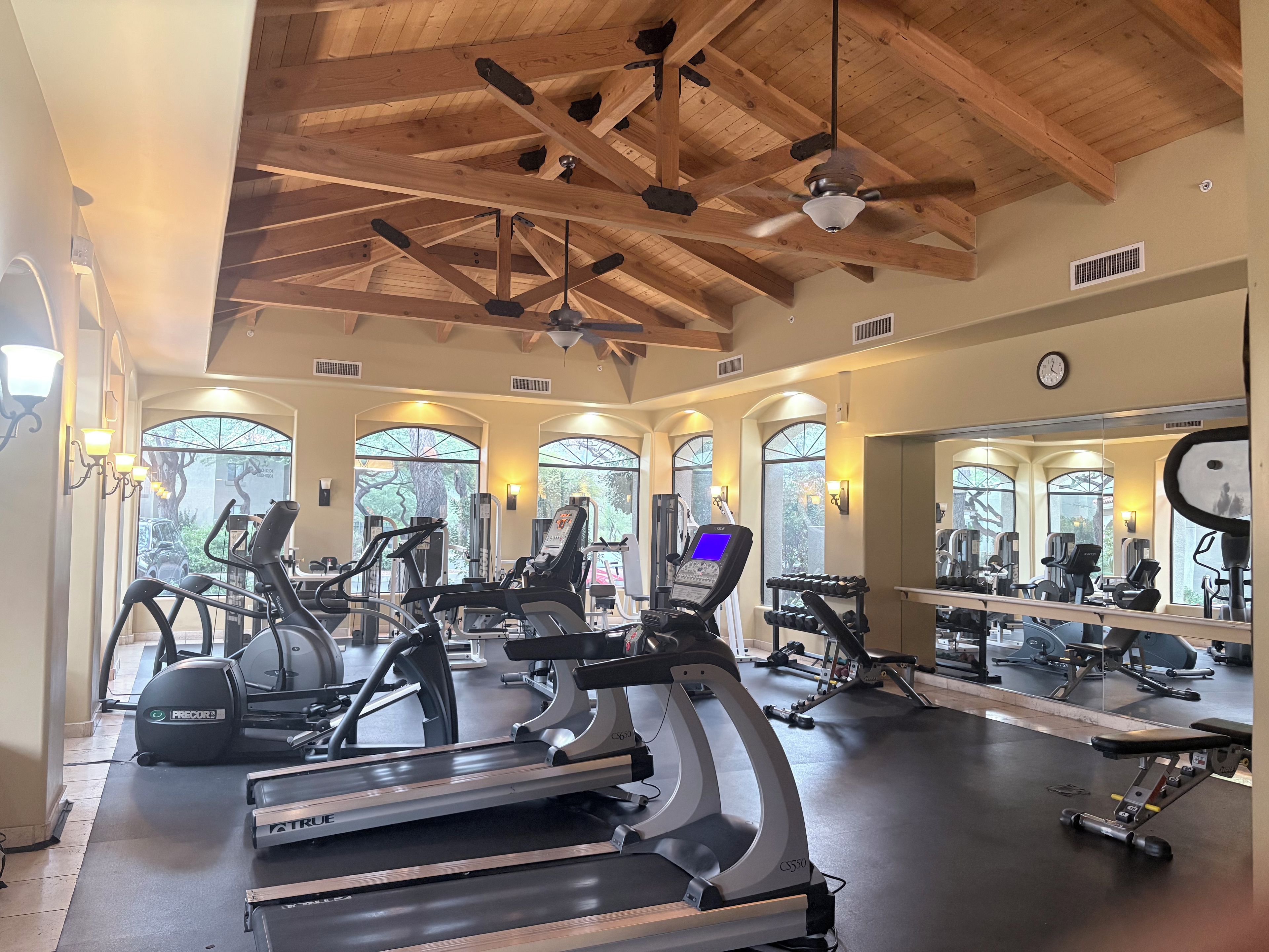 A gym with treadmills, exercise bikes, and weight machines.