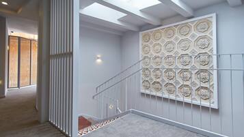 Una escalera con un papel tapiz decorado y una lámpara.