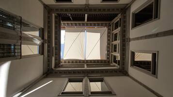 A corridor with a central open space, flanked by windows and a staircase.