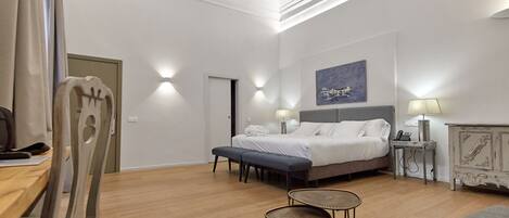 Ein modernes Schlafzimmer mit einem Bett, Nachttischen, einem Schreibtisch und einem Stuhl.