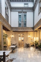 A courtyard with a bar area, multiple seating arrangements, and a tiled floor.