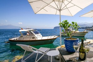 A boat docked at a marina with a clear view of the sea and distant mountains.