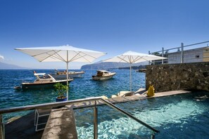 A clear blue sea with boats, a stone wall, and umbrellas. - My Exclusive Italy - Beachfront Villa Sorrento & private sea access (Sorrento)