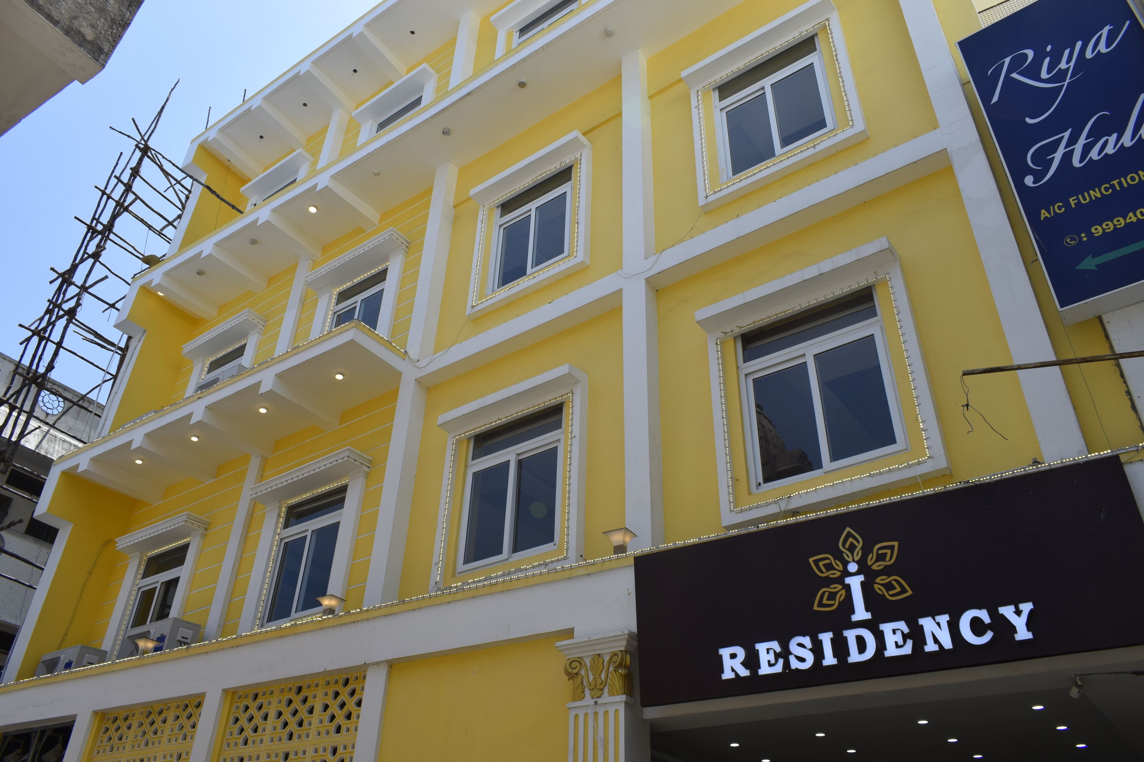 Um edifício amarelo de vários andares com uma placa indicando "I Residency".