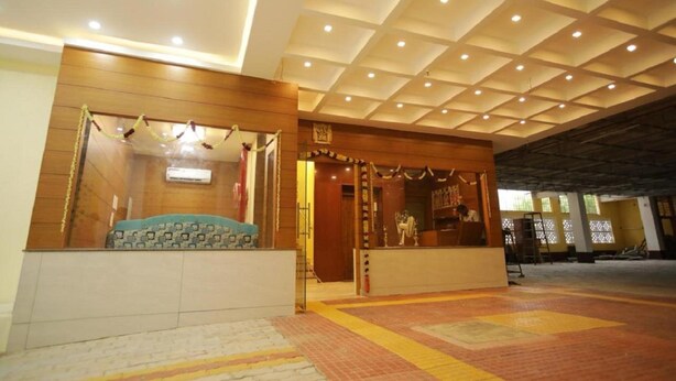 A hotel lobby with a tiled floor, a reception desk, and a ceiling with recessed lighting. - I Residency (Puducherry)