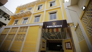 A multi-story building with a yellow facade and a sign that reads "RESIDENCY." - I Residency (Puducherry)